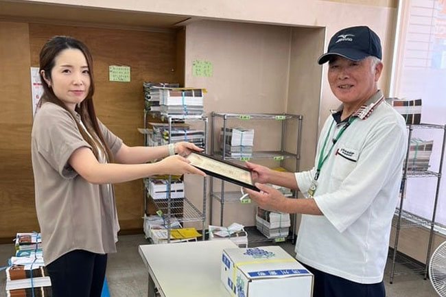 拠点で配布パートナーにチラシを渡すところ